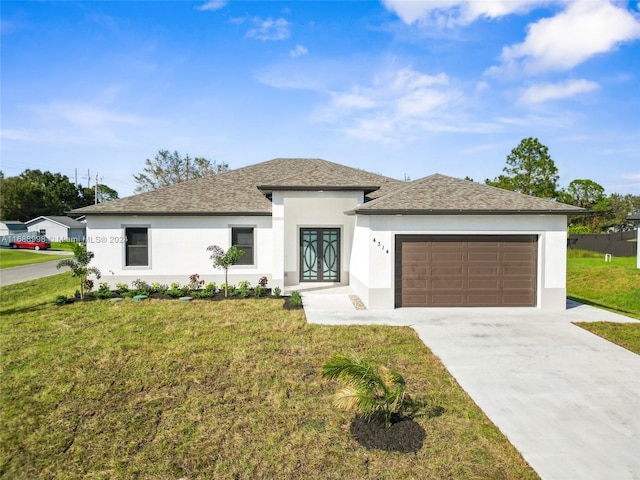 prairie-style house featuring a garage and a front lawn