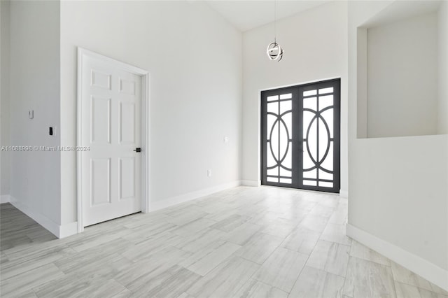 foyer with a towering ceiling and french doors