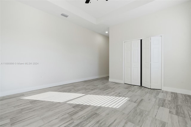 unfurnished bedroom featuring ceiling fan, a closet, and light hardwood / wood-style flooring