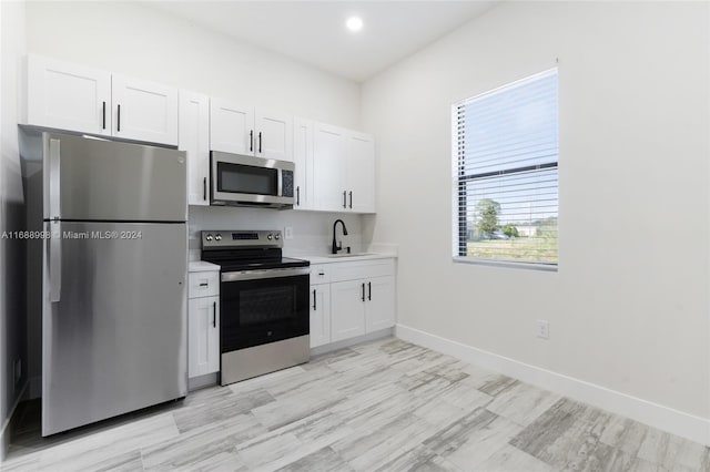 kitchen with white cabinets, appliances with stainless steel finishes, and sink