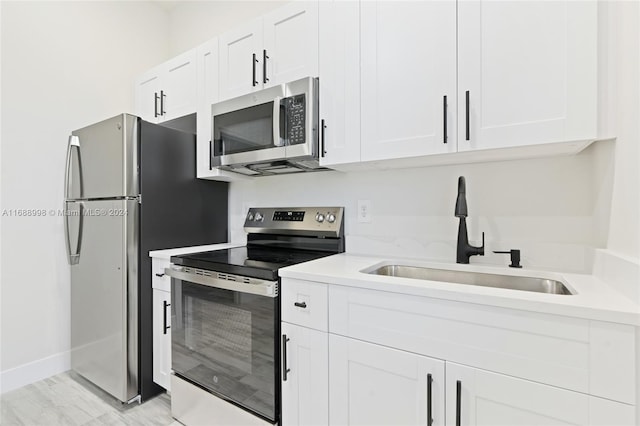 kitchen with white cabinetry, stainless steel appliances, and sink