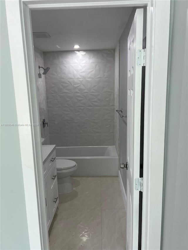 full bathroom featuring tile patterned flooring, vanity, toilet, and tiled shower / bath