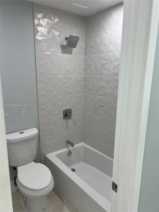 bathroom with toilet and tiled shower / bath combo