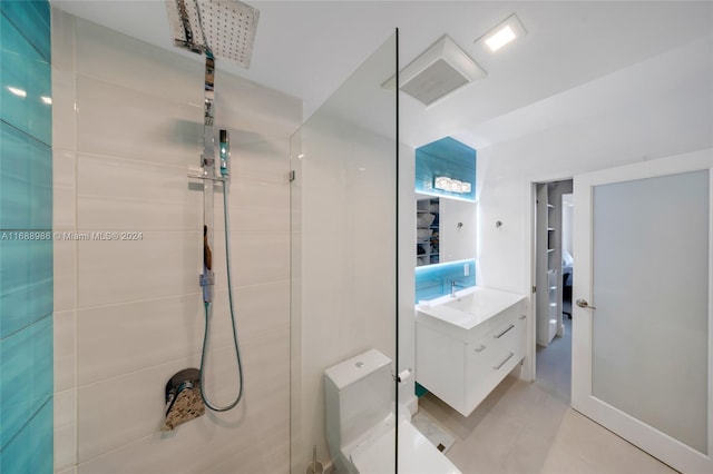 bathroom with tiled shower and vanity