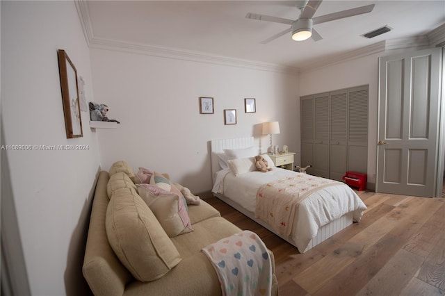 bedroom with ornamental molding, a closet, ceiling fan, and light hardwood / wood-style floors