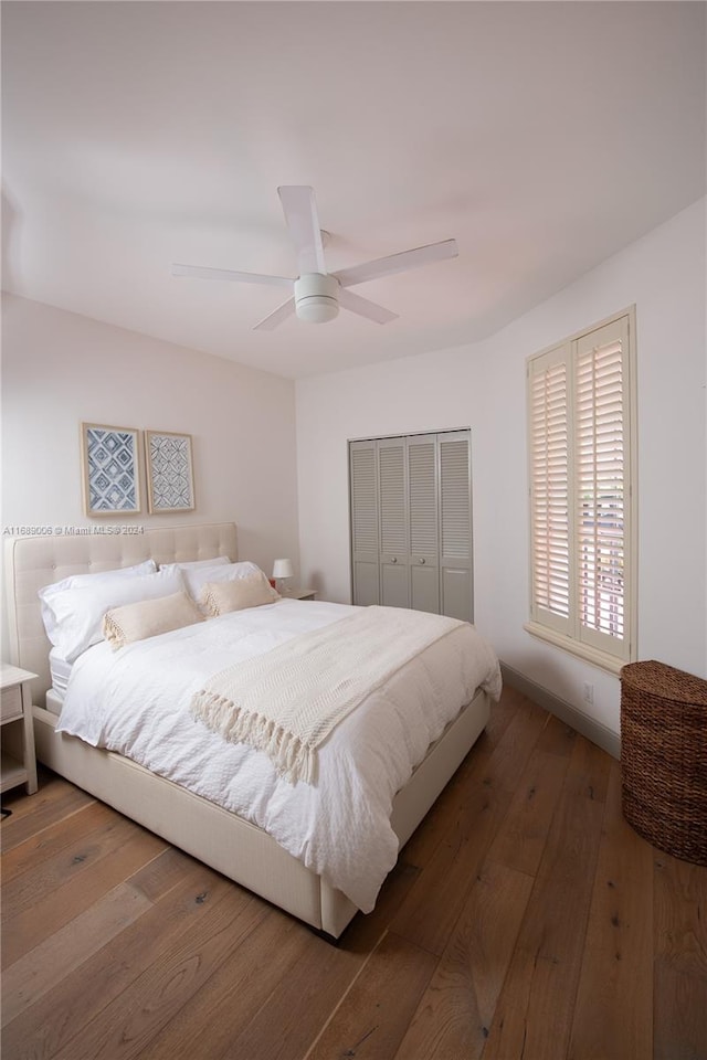 bedroom with hardwood / wood-style flooring, ceiling fan, and a closet