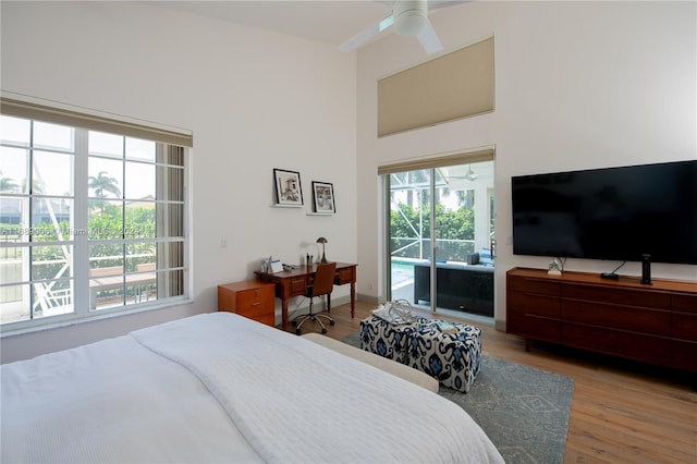 bedroom with hardwood / wood-style flooring, access to outside, and ceiling fan