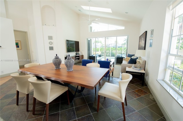 dining room with high vaulted ceiling, a wealth of natural light, ceiling fan, and a skylight