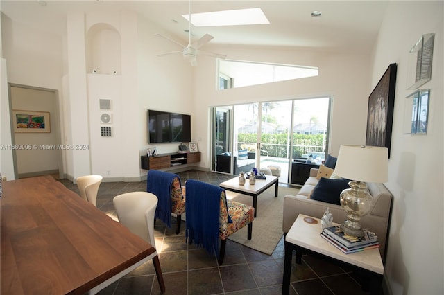 living room featuring dark tile patterned flooring, ceiling fan, and high vaulted ceiling