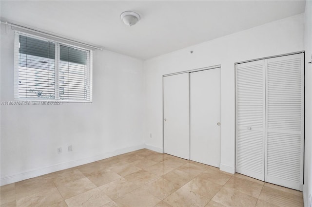 unfurnished bedroom featuring two closets