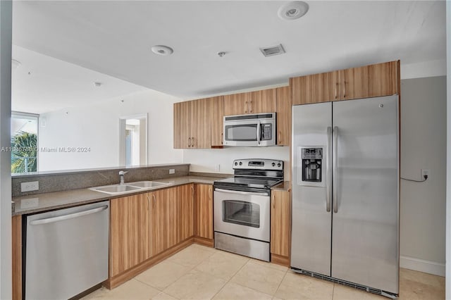 kitchen with sink, light tile patterned floors, and stainless steel appliances