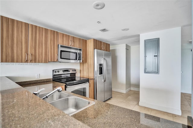 kitchen featuring electric panel, sink, light tile patterned flooring, and stainless steel appliances