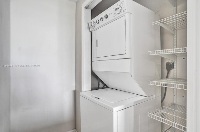 clothes washing area with stacked washer and clothes dryer