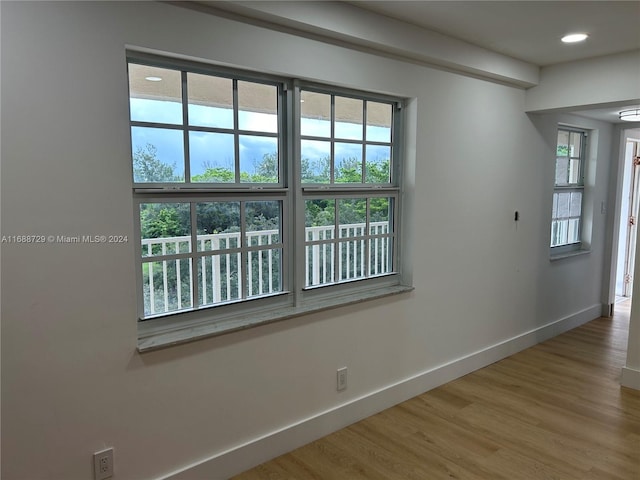 unfurnished room featuring hardwood / wood-style flooring and a healthy amount of sunlight