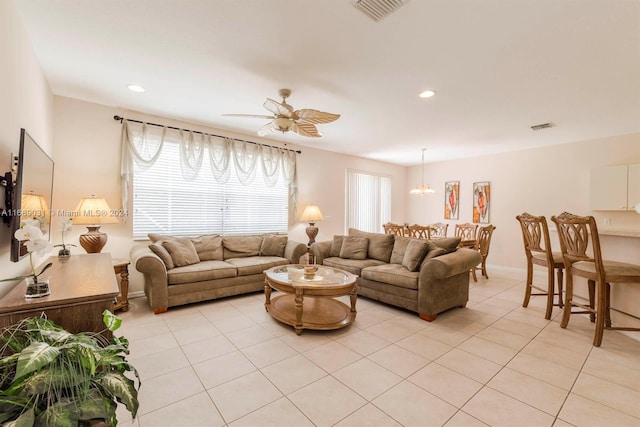 living room featuring ceiling fan with notable chandelier and light tile patterned floors