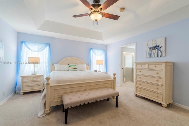 bedroom featuring ceiling fan, light carpet, and a raised ceiling