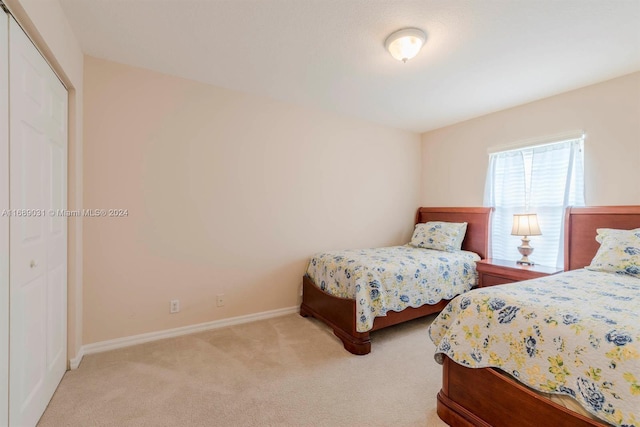 bedroom with light carpet and a closet