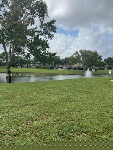 surrounding community featuring a water view and a lawn