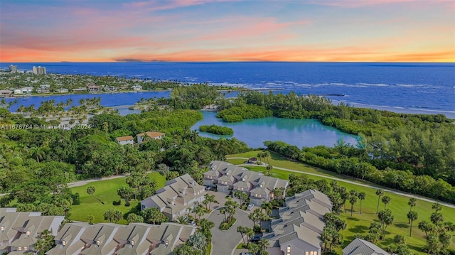 aerial view at dusk featuring a water view