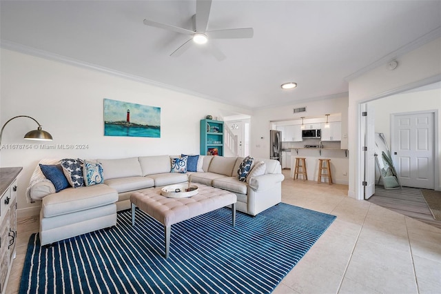 living room with ornamental molding, ceiling fan, and light tile patterned floors