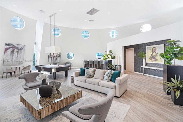 living room featuring light hardwood / wood-style floors and a towering ceiling