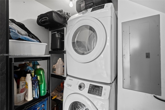 laundry room with electric panel and stacked washer and clothes dryer