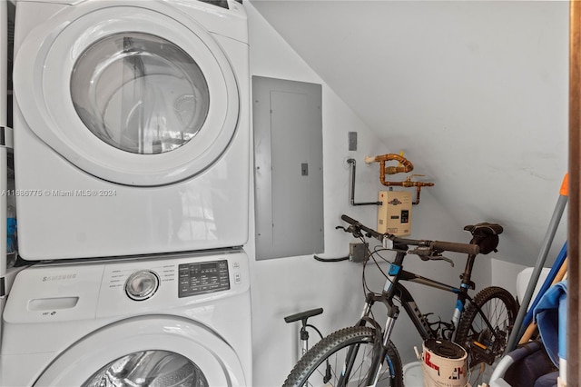 clothes washing area featuring stacked washer and dryer and electric panel