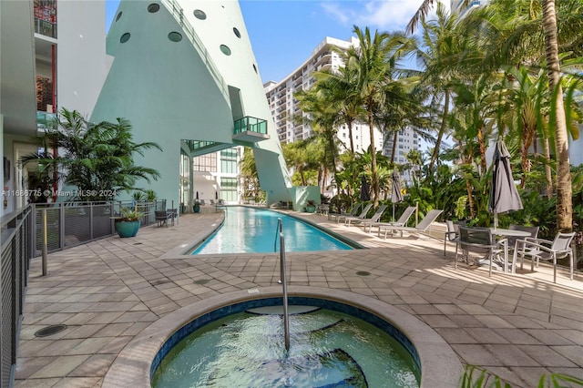 view of swimming pool featuring a patio and a community hot tub