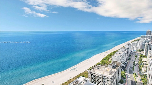 bird's eye view with a water view and a beach view