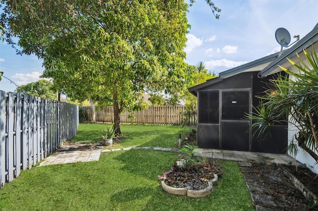 view of yard with a sunroom and a fenced backyard