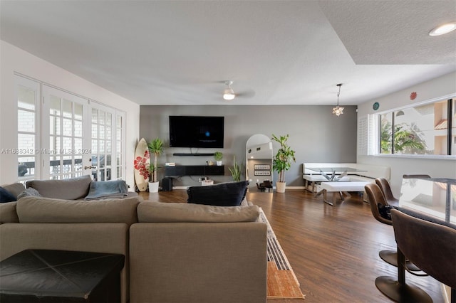 living room with a textured ceiling and dark hardwood / wood-style flooring