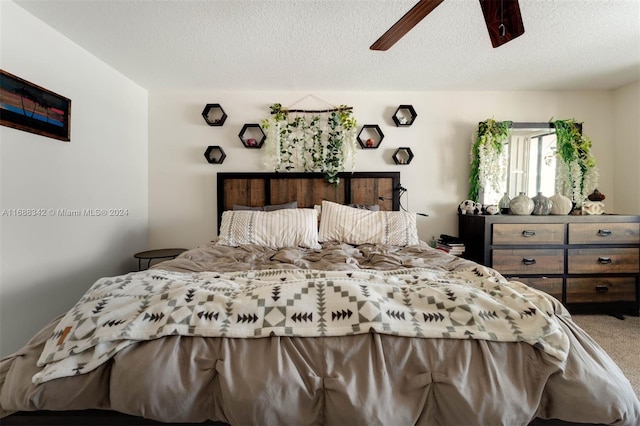 bedroom with ceiling fan, a textured ceiling, and carpet