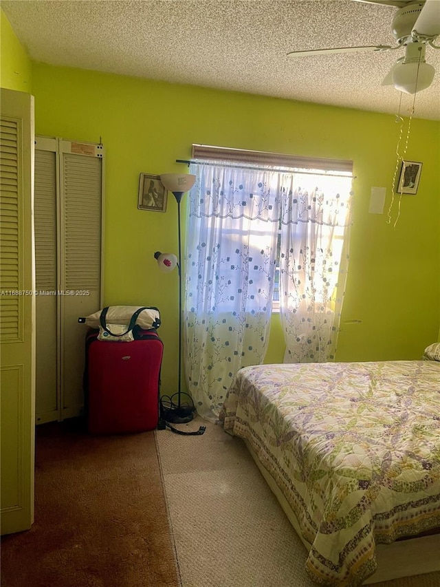 bedroom with carpet flooring, a wall mounted AC, ceiling fan, and a textured ceiling