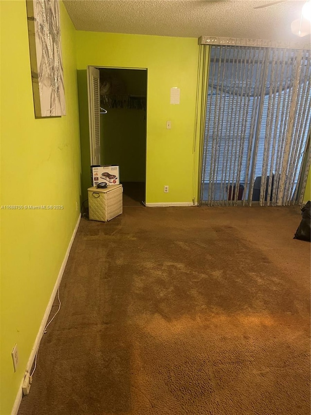 carpeted spare room with a textured ceiling