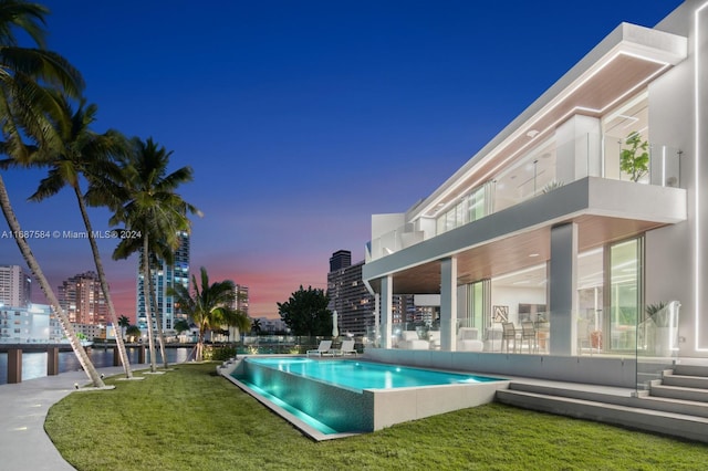 pool at dusk with a lawn