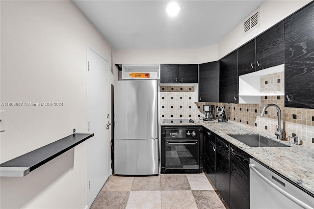 kitchen with stainless steel appliances, sink, light stone counters, and backsplash