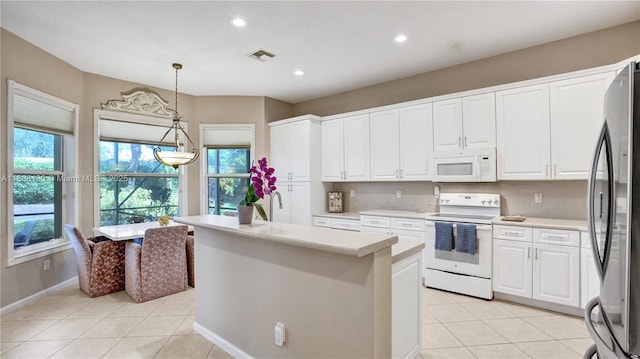 kitchen featuring stainless steel fridge, range with electric stovetop, light tile patterned floors, decorative light fixtures, and white cabinetry