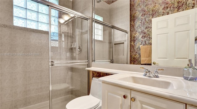 bathroom with vanity, toilet, and a shower with shower door