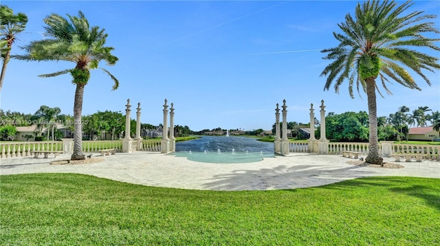 view of swimming pool featuring a water view and a lawn