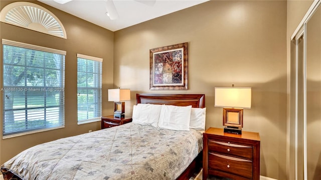 bedroom featuring ceiling fan, a closet, and multiple windows