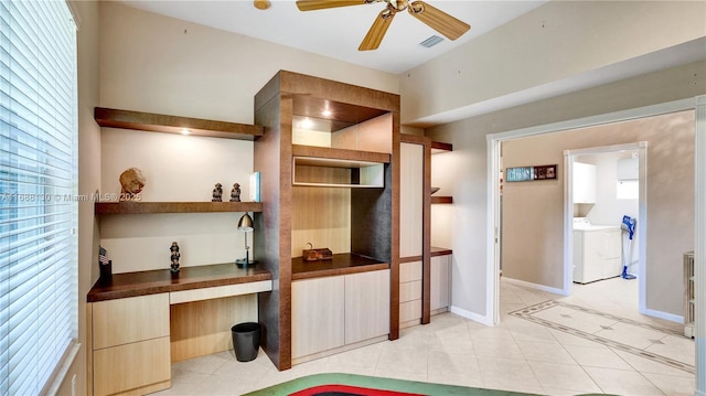 kitchen with ceiling fan, washing machine and dryer, and built in desk