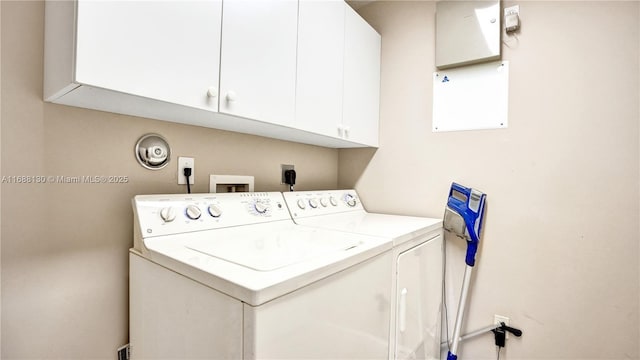 washroom featuring cabinets and washing machine and clothes dryer