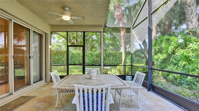 unfurnished sunroom with ceiling fan