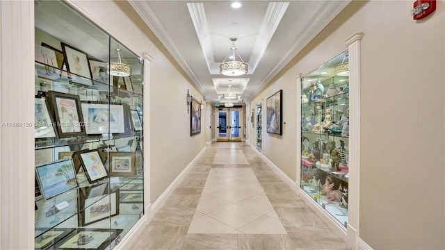 hall featuring light tile patterned floors, crown molding, and a tray ceiling