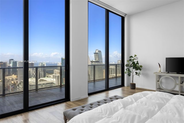 bedroom with wood-type flooring and a wall of windows