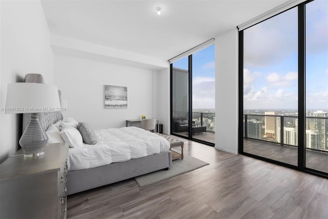 bedroom with hardwood / wood-style floors, access to outside, and floor to ceiling windows