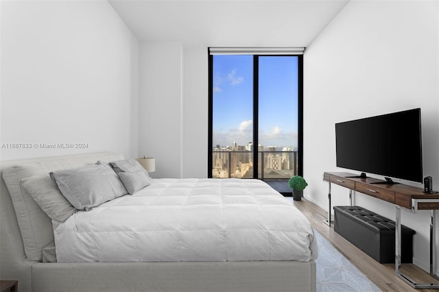 bedroom featuring light hardwood / wood-style floors and floor to ceiling windows