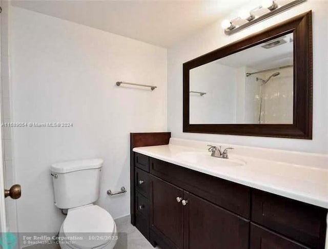 bathroom featuring a shower, vanity, and toilet