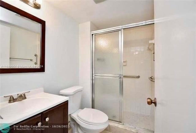 bathroom featuring vanity, toilet, and walk in shower