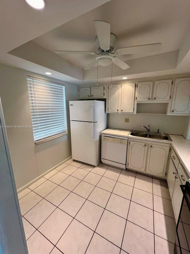 kitchen featuring white appliances, a raised ceiling, ceiling fan, and sink